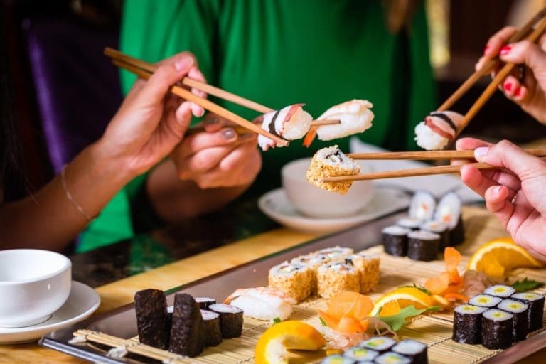 group of people eating sushi